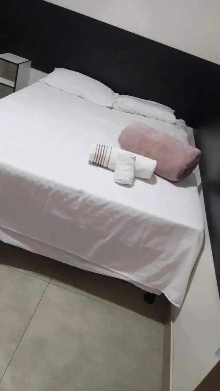 Cama arrumada com enxoval branco