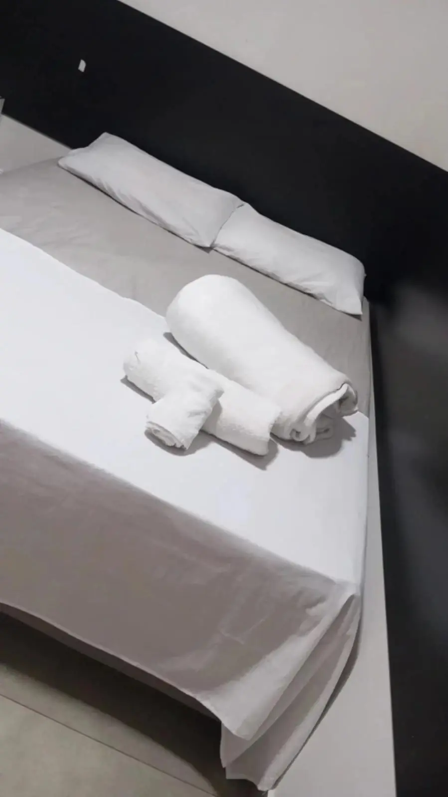 Detalhe da cama com toalhas dobradas