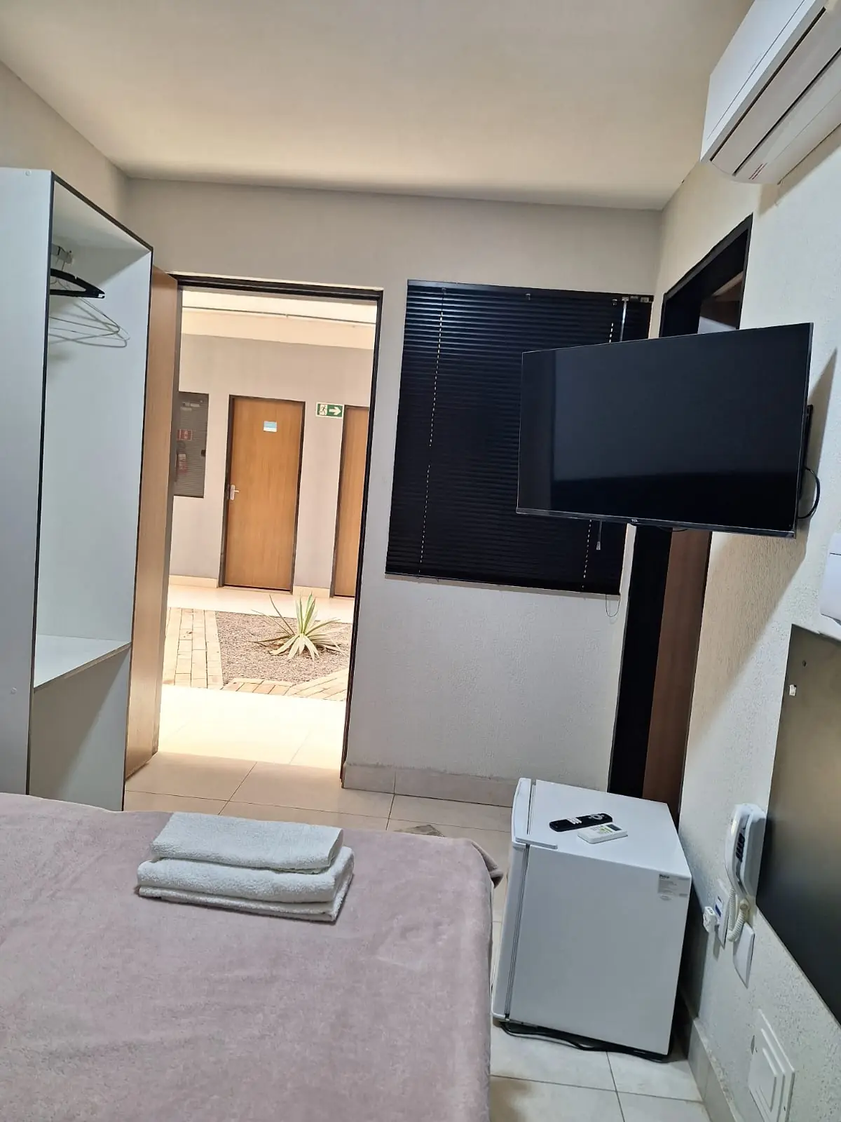 Entrada da suíte com televisão e frigobar