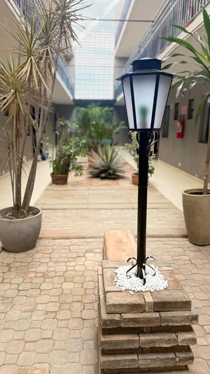 Pátio interno do Hotel SIGA com luminária e vasos de plantas